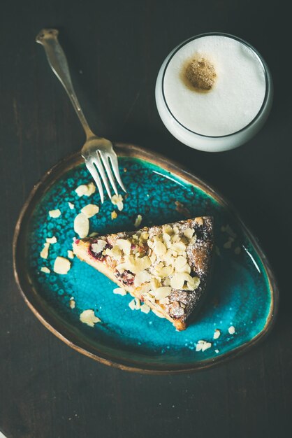 Pezzo di torta al limone, ricotta e mandorle, lamponi e caffè