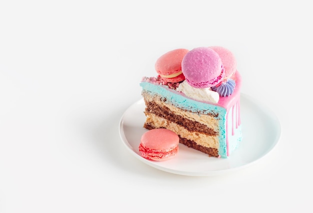 Pezzo di torta con decorazioni rosa e blu su piatto bianco