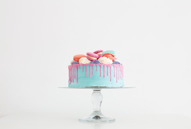 Pezzo di torta con decorazioni rosa e blu su sfondo bianco