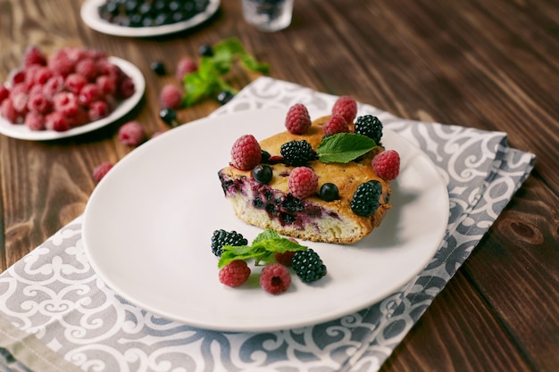 Pezzo di torta con mirtilli, lampone e menta per dessert