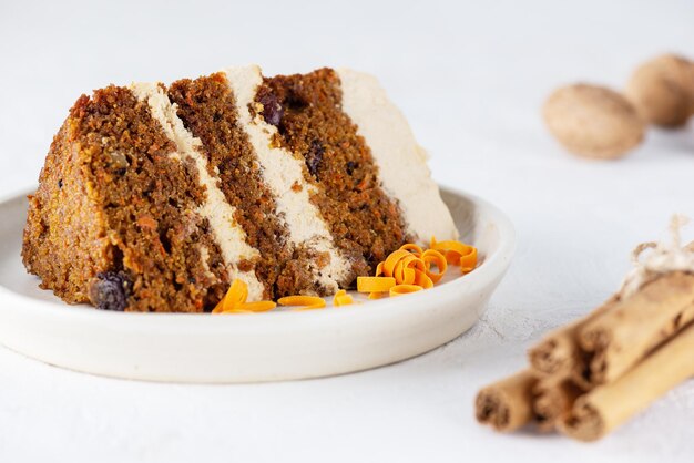 Pezzo di torta di carote con crema di cocco noci e cannella su un piatto