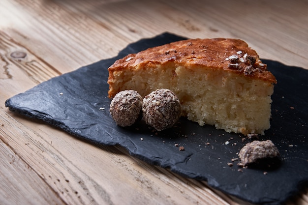 pezzo di torta di mele con cioccolato grattugiato vicino caramelle al tartufo al cioccolato.