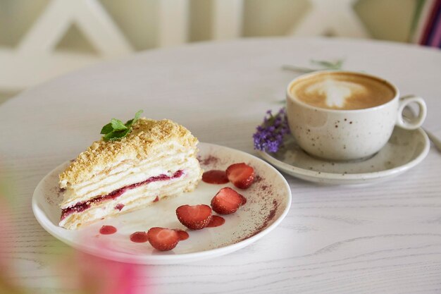 Pezzo di torta di Napoleone e tazza di cappuccino sulla tavola di legno nella caffetteria Tempo estetico del caffè Tempo per te stesso