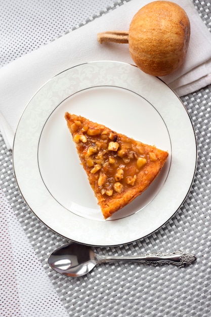 Pezzo di torta di zucca con le noci su un piatto