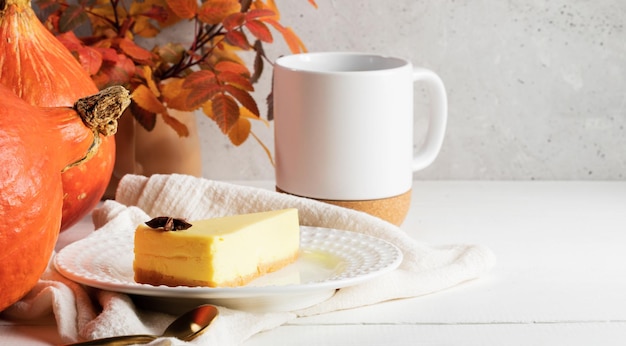 Pezzo di torta di zucca su piatto bianco tazza di tè o caffè con foglie colorate di zucche Copia spazio