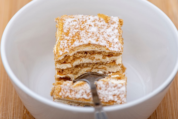 Pezzo di torta dolce del primo piano con il cucchiaio in piatto bianco, dieta, sport