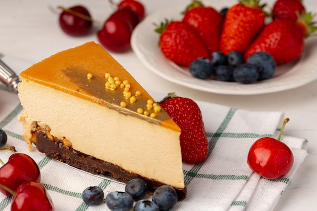 Pezzo di torta soufflé con cima al caramello servita con frutti di bosco