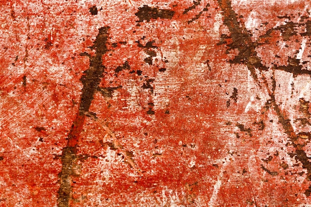 Pezzo graffiato gravemente danneggiato di legno dipinto di rosso. Foto ad alta risoluzione.