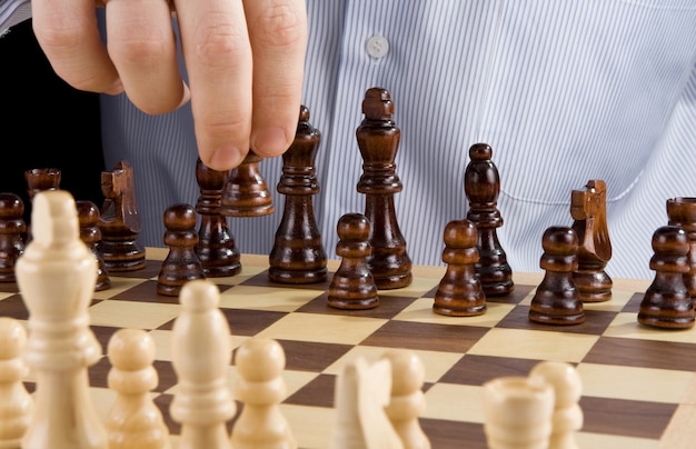 Pezzo nero degli scacchi in movimento a mano maschile