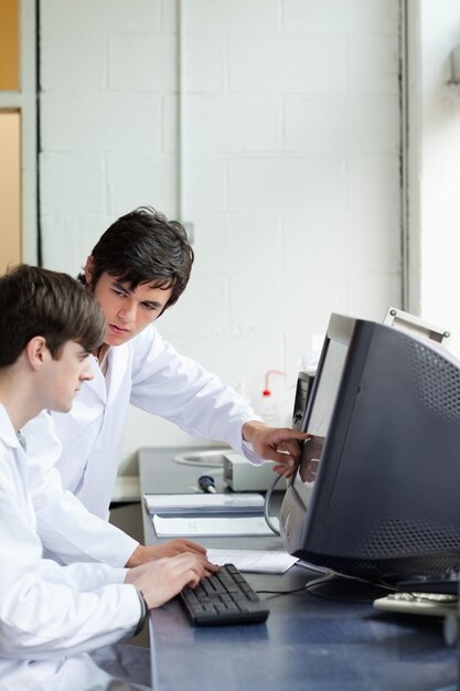 Phisician che indica qualcosa su un monitor al suo studente