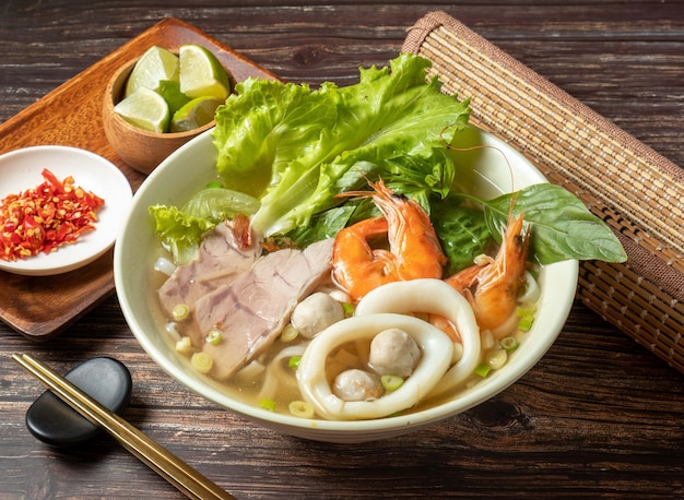 Pho di pesce con calamari e gamberi serviti in una ciotola isolata sulla vista del tavolo del cibo taiwan