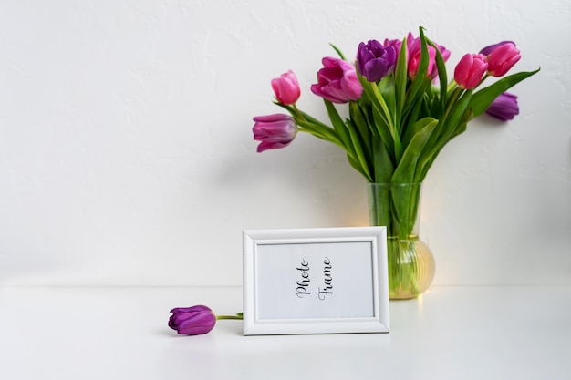 Photofame mock up sul tavolo con vaso con tulipani