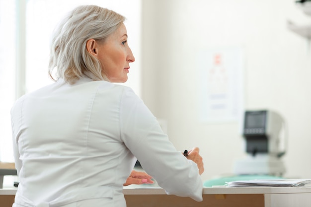 Piacevole donna bionda che lavora come oculista professionista