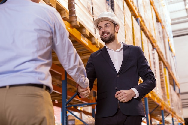 Piacevole incontro. Felice imprenditore positivo sorridendo mentre saluta il suo lavoratore