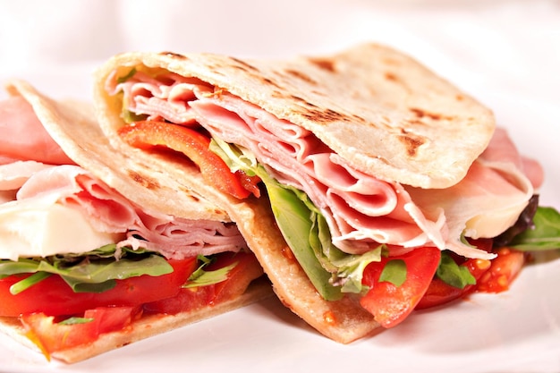 Piadina tradizionale italiana con prosciutto, pomodoro e insalata