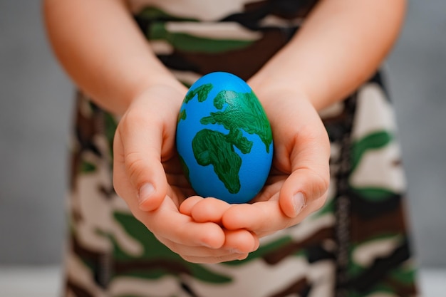 Pianeta Terra a forma di uovo nelle mani dei bambini primo piano Il concetto di problemi globali dell'umanità pace al mondo nessuna guerra