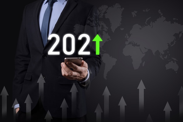 Pianificare la crescita positiva del business nel concetto di anno 2021. Piano dell'uomo d'affari e aumento degli indicatori positivi nella sua attività, crescendo concetti di business.