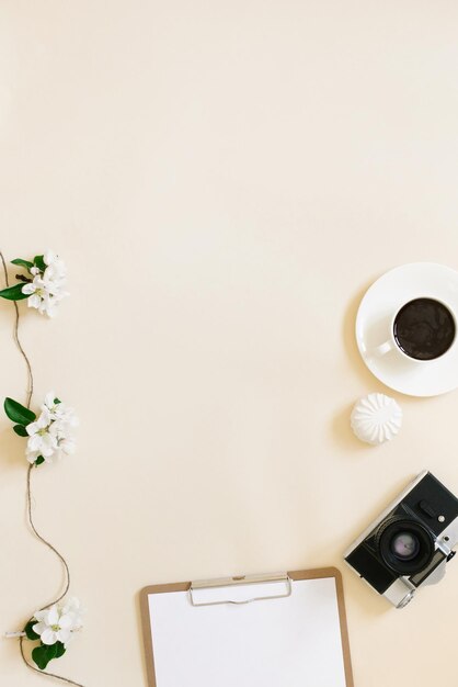 Pianificare un viaggio di primavera un tablet con un foglio bianco di carta una telecamera retro fiori di mele bianche