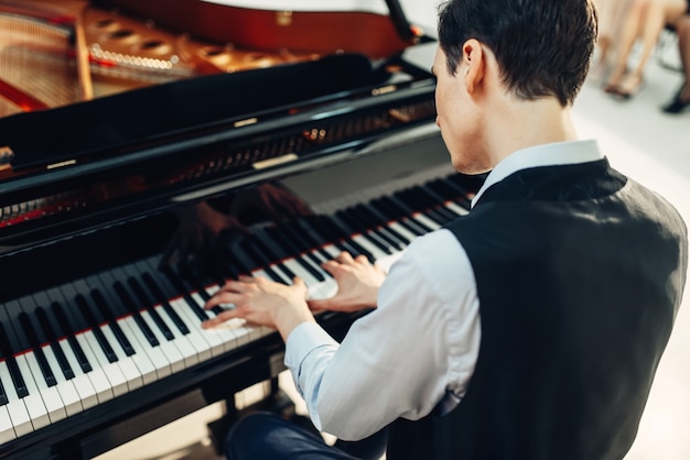 Pianista che suona musica al pianoforte a coda