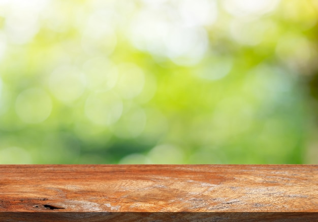 Piano d'appoggio di legno di Brown su un fondo verde della sfuocatura del bokeh.