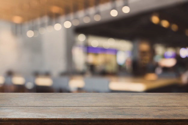 Piano d&#39;appoggio di legno e caffè del bokeh e fondo interni vaghi della caffetteria con il filtro d&#39;annata - possono usare per esposizione o il montaggio i vostri prodotti.