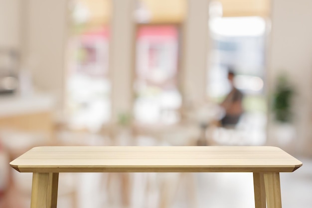 Piano d'appoggio di legno vuoto con il fondo interno della sfuocatura del ristorante del caffè