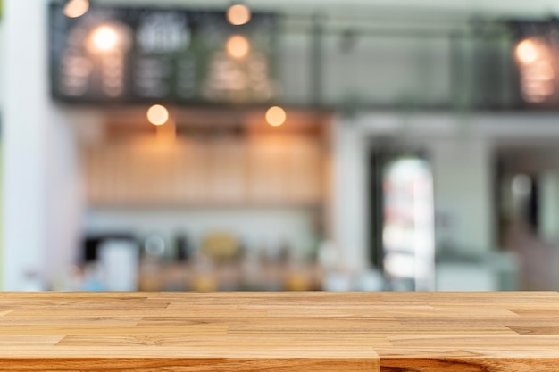 Piano d'appoggio in legno vuoto con luci bokeh su sfondo ristorante sfocato sullo sfondo della barra della caffetteria del caffè