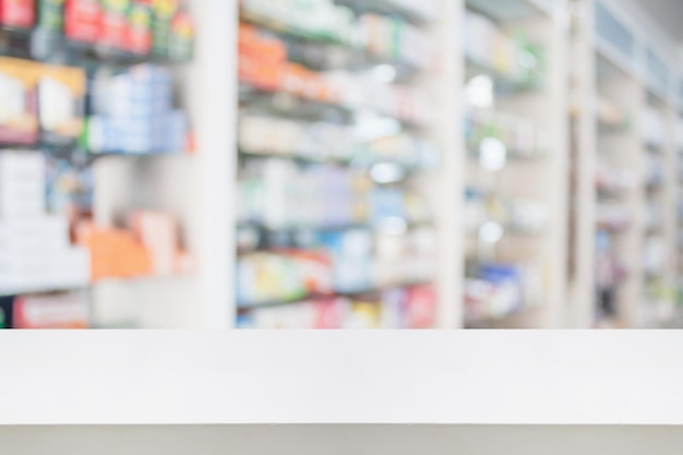 Piano del bancone della farmacia con medicina sfocata sugli scaffali sullo sfondo della farmacia