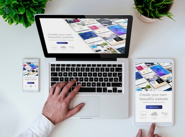 Piano del tavolo da ufficio con tablet, smartphone e laptop che mostra il costruttore di siti Web