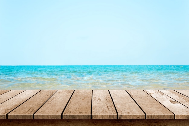 Piano del tavolo in legno con spiaggia di sfocatura