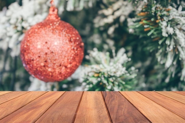 Piano del tavolo in legno vuoto con albero di Natale sfocato con sfondo chiaro bokeh