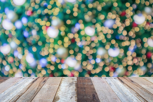 Piano del tavolo in legno vuoto con albero di Natale sfocato con sfondo chiaro bokeh