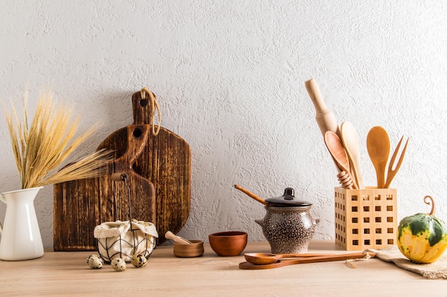 Piano di lavoro in legno della fattoria della cucina con vari utensili da cucina e prodotti agricoli il concetto dell'arredamento di una casa di campagna