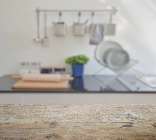 Piano tavolo in legno con sfocatura di moderne stoviglie in ceramica e utensili sul bancone