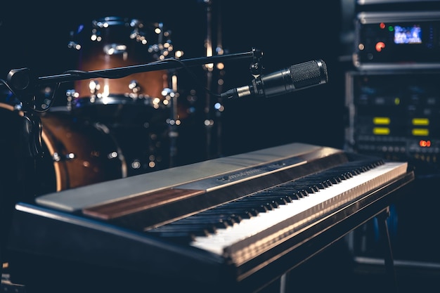 Pianoforte e microfono su uno sfondo scuro all'interno di uno studio musicale