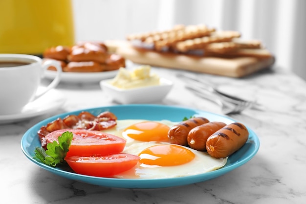 Piastra con la tradizionale colazione inglese sul tavolo di marmo