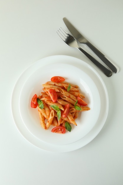 Piastra con pasta con salsa di pomodoro su sfondo bianco isolato