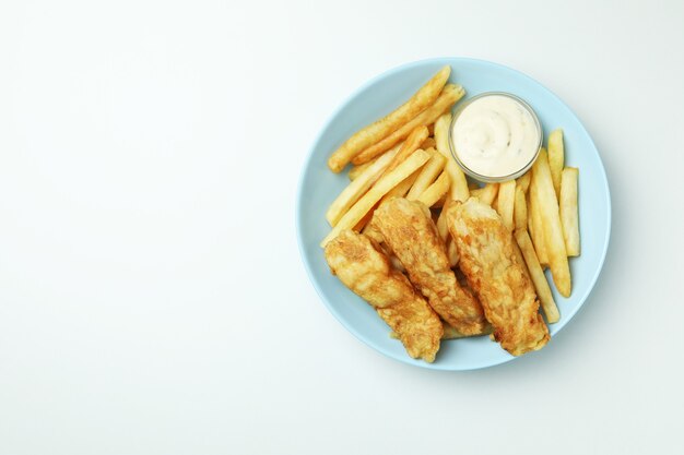 Piastra con pesce fritto e patatine fritte e salsa isolata