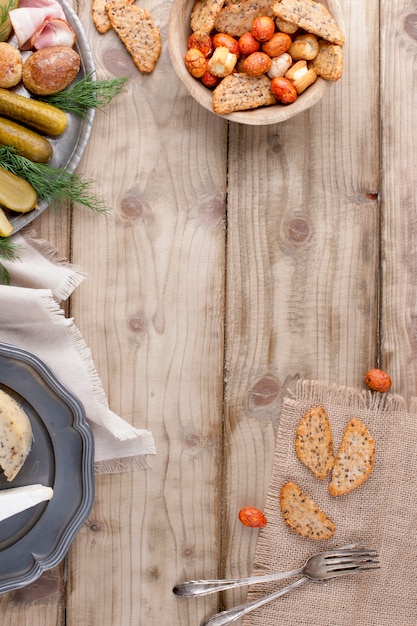 piastra metallica con patate al forno e cetrioli e verdure, fette biscottate e formaggio su un tavolo di legno