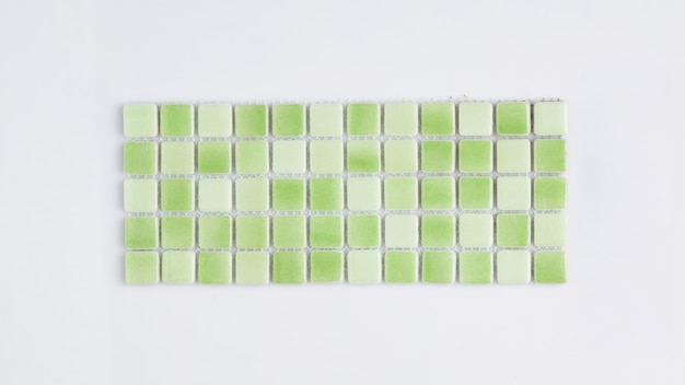 Piastrella ceramica verde su fondo bianco, vista dall'alto, maiolica. per il catalogo