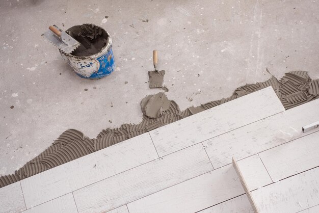Piastrelle in ceramica effetto legno e attrezzi per piastrellista a pavimento posa piastrelle grezze Installazione piastrelle per pavimenti
