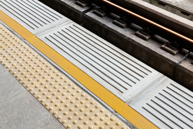 Piastrelle per pavimenti cieche sulla piattaforma della stazione ferroviaria