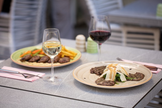 Piatti con carne e bicchiere di vino