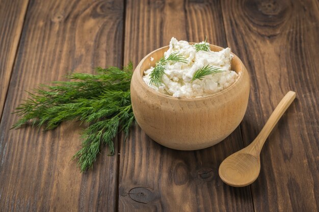 Piatti in legno con ricotta fresca fatta in casa su un tavolo di legno. Il concetto di una dieta sana.