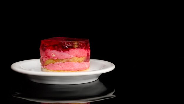 Piattino con torta su sfondo nero