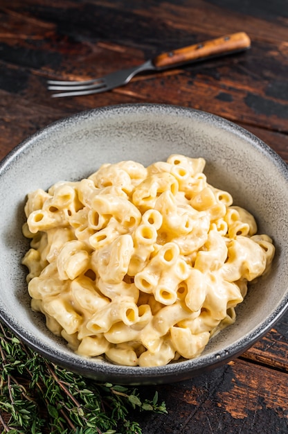 Piatto americano Mac e maccheroni al formaggio con Cheddar. Fondo in legno scuro. Vista dall'alto.