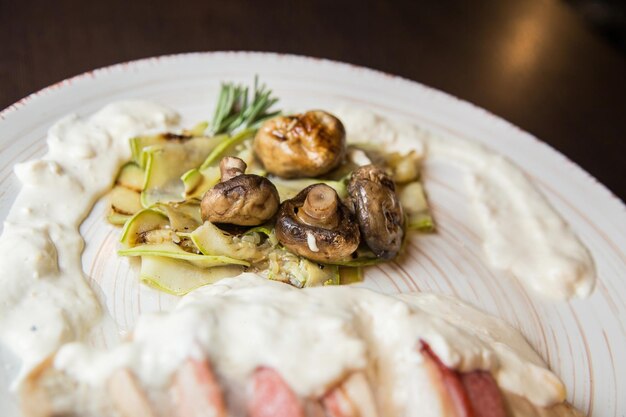 Piatto appetitoso nel ristorante. Pancetta cremosa con funghi