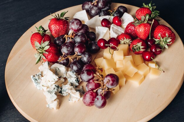 Piatto assortito di frutta e formaggio Primo piano del delizioso piatto di cibo