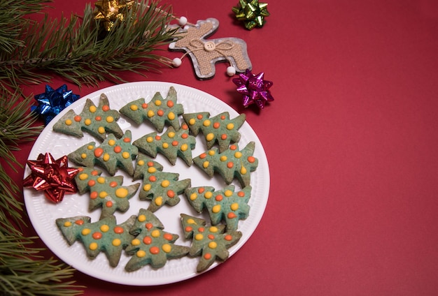 Piatto bianco con pan di zenzero di Natale a forma di rami di pino di alberi di Natale