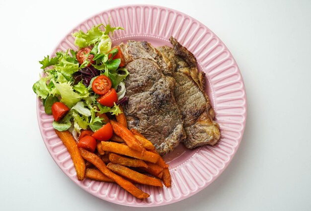 Piatto combinato di bistecca con patate dolci fritte e insalata